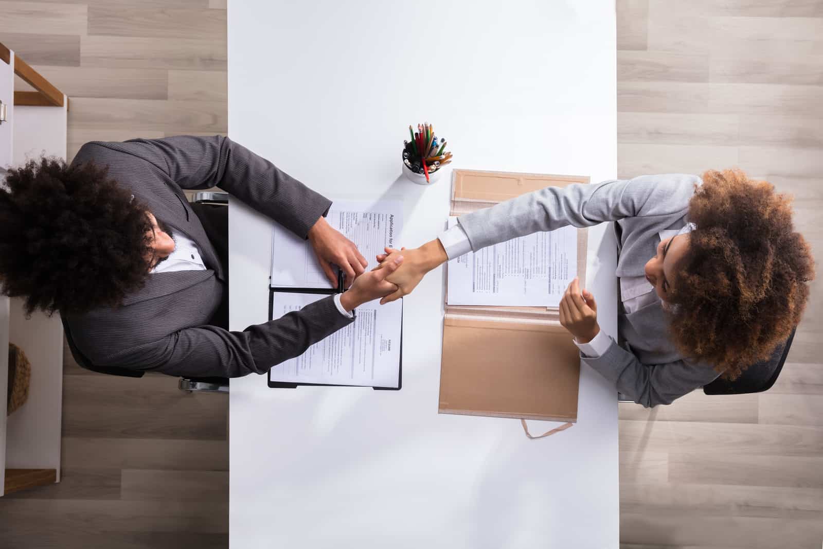 Aerial view of two people shaking hands during a job interview