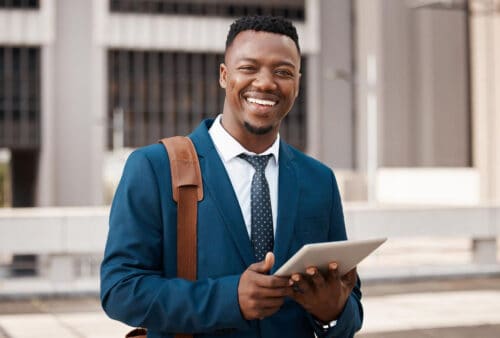 Man holding tablet looks happy. Learn about real estate agent demographics in CA.